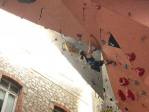 Une grimpeuse unijambiste escalade un dévers.