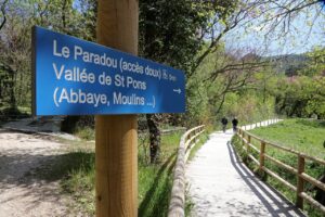 Panneau de signalisation indiquant "Le Paradou (accès doux), Vallée de Saint-Pons (Abbaye, Moulins...)"